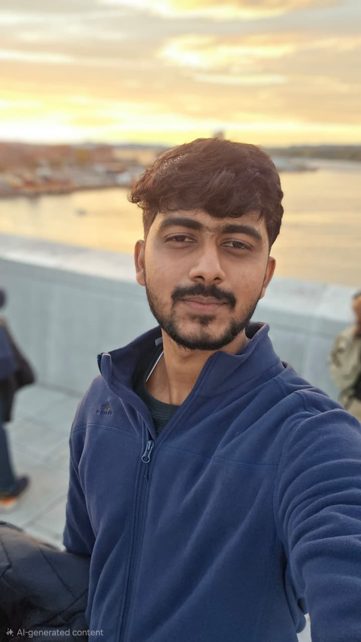 Man in a blue jacket taking a selfie with a blurred background